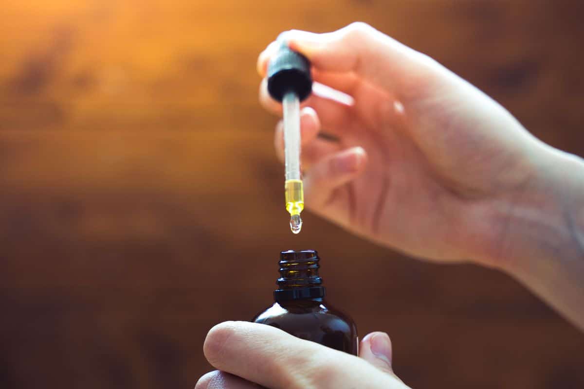 A lady holding CBD tincture in her hand A lady holding CBD tincture in her hand