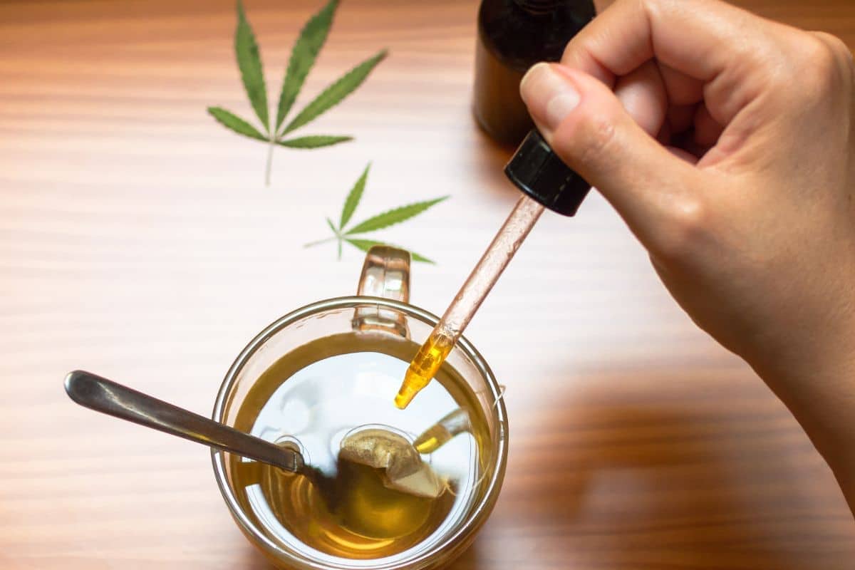 A man adding delta 9 tincture in his tea A man adding delta 9 tincture in his tea