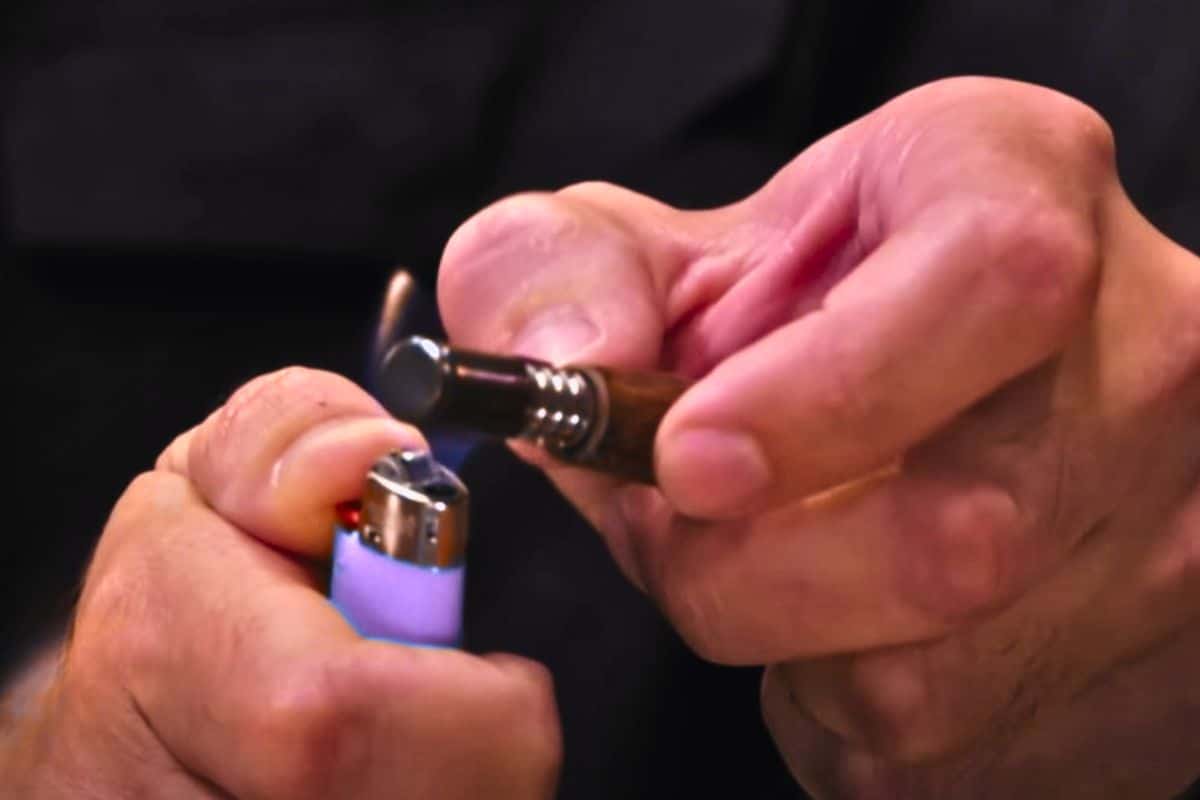 A guy hitting cartridge with the help of lighter