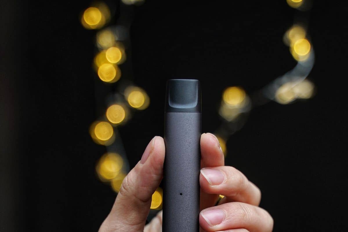 A guy holding stiiizy vape pod in his hand