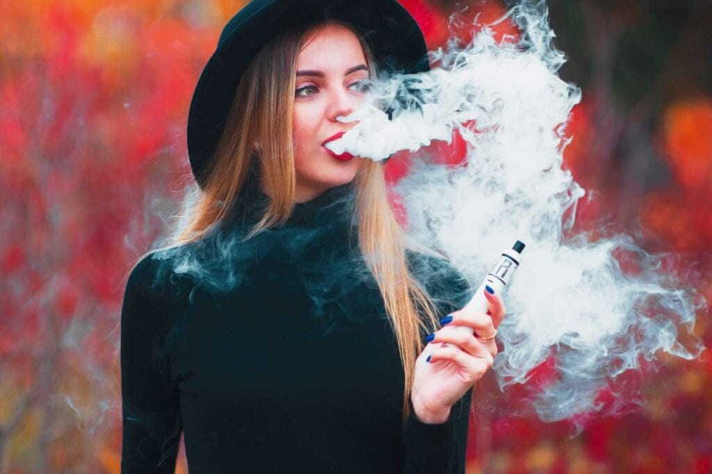A woman vaping delta 8 thc outdoors
