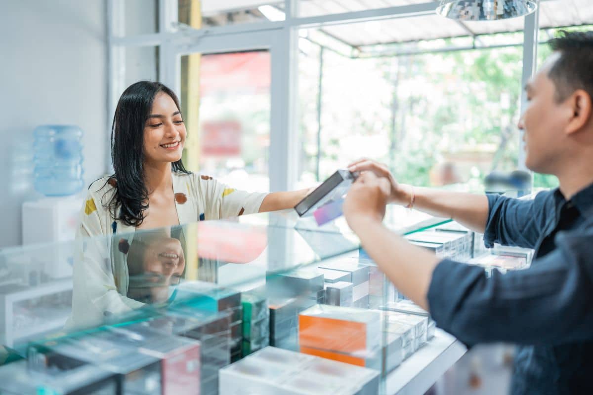 Customer making a payment with a credit card and identification at a store counter.