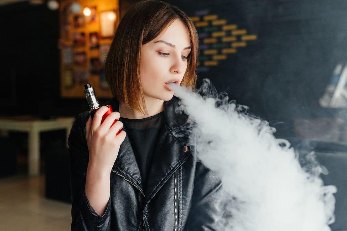 Woman exhaling vapor from one of the best clear electronic cigarettes.