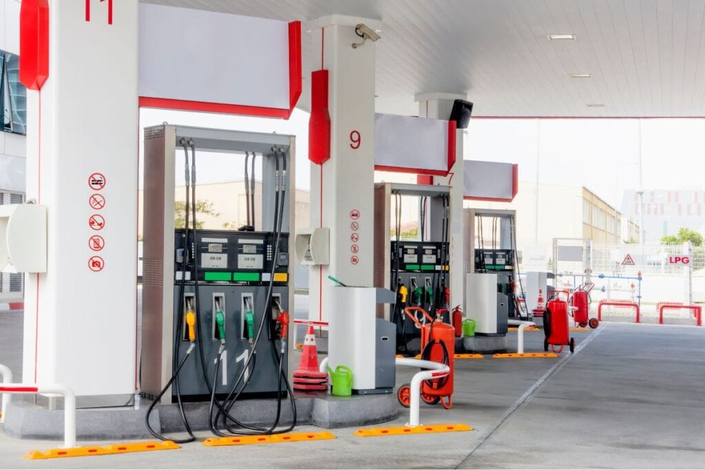 A 'No Vaping' and 'No Smoking' sign, along with other precautions, is posted in the petrol pump area