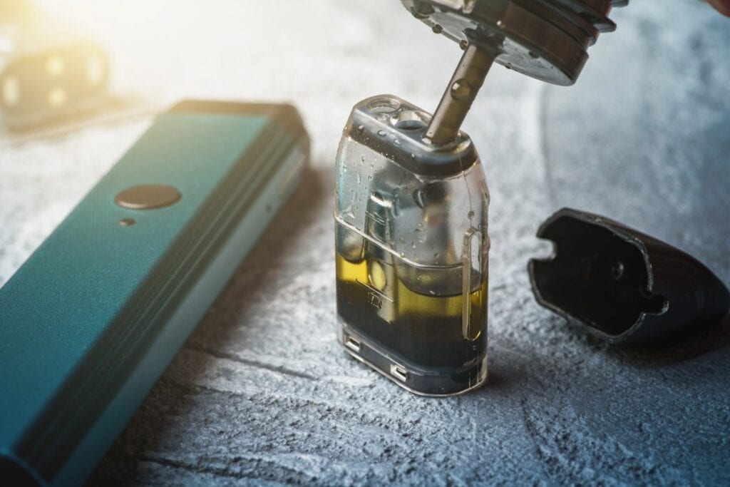 A person carefully filling a vape cartridge with high-quality cannabis oil